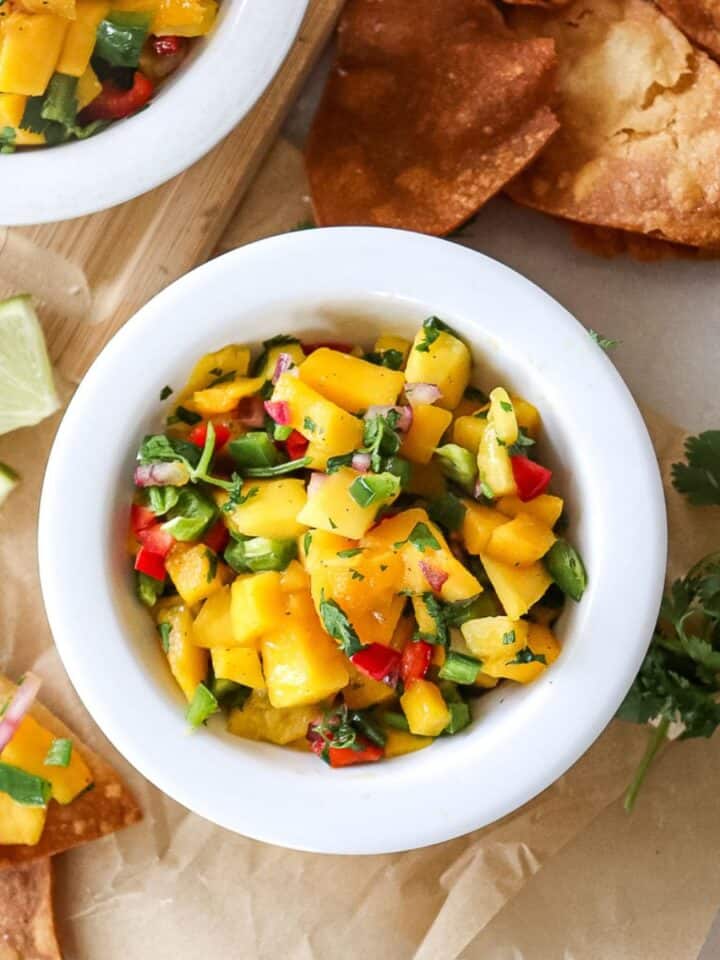a bowl of mango salsa with homemade tortilla chips next to it