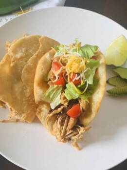 plated chalupas beside avocado slices and lime wedge