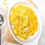 macaroni and cheese with crab in a bowl with a spoon next to it
