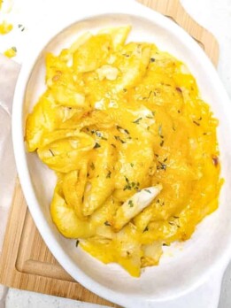 macaroni and cheese with crab in a bowl with a spoon next to it