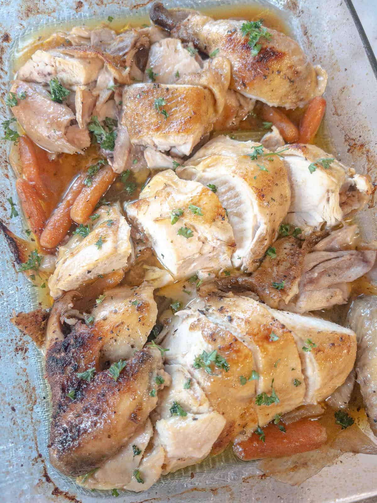 chicken roasted in the oven cut into pieces in a baking dish