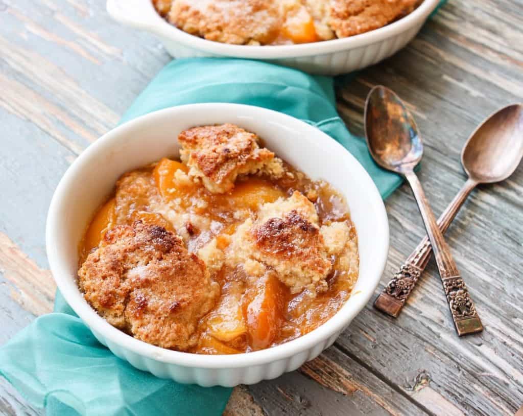 a bowl of cobbler beside two spoons