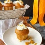 pumpkin muffin with cream cheese filling sitting on a white plate