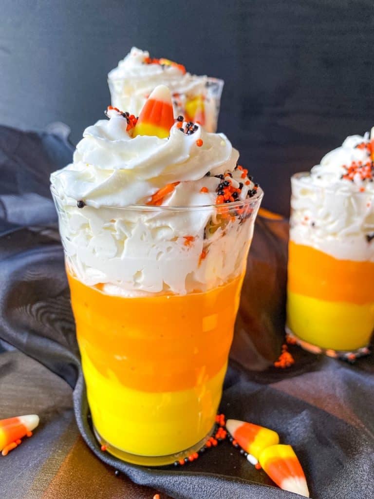 one candy corn pudding cup with whipped cream