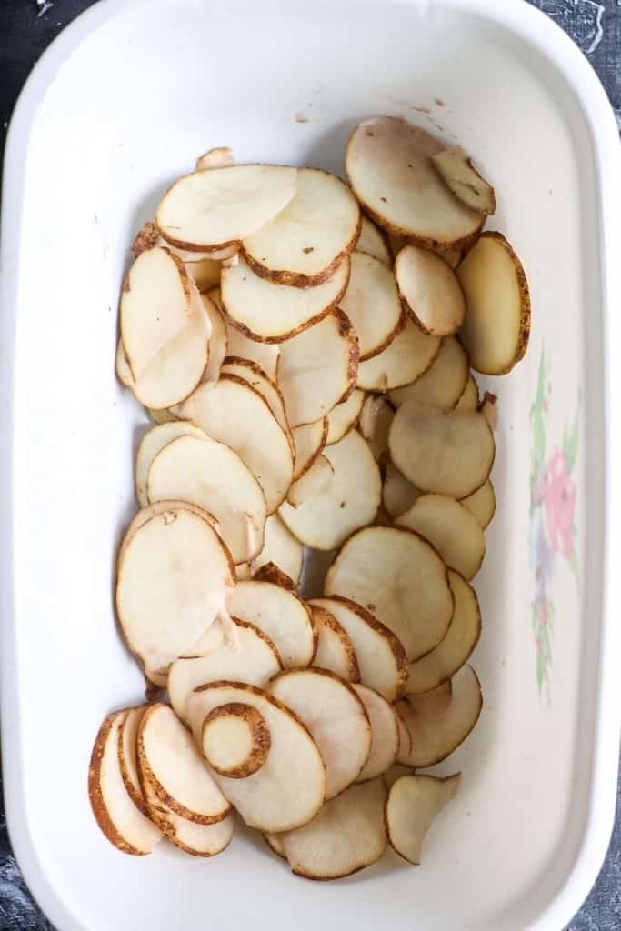 raw thinly sliced potatoes in a bowl