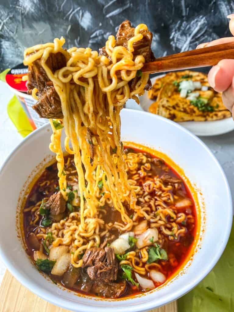 noodle pull of birria ramen wiht beef