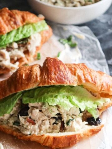 chicken salad on croissants with a piece of lettuce as garnish