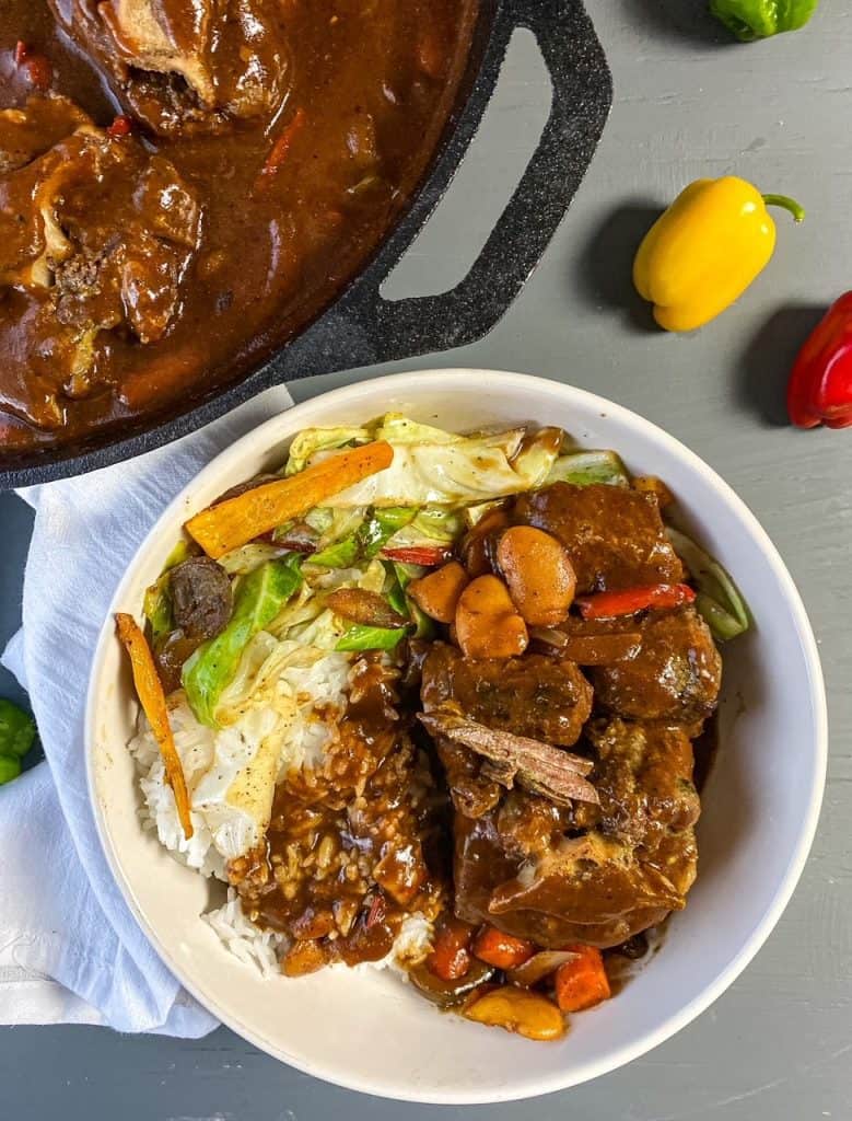 flat lay of oxtials in a bowl with rice and cabbage