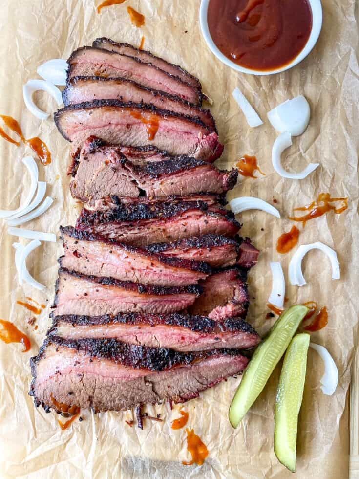 sliced up front angle of bbq beef brisket with onions and pickles
