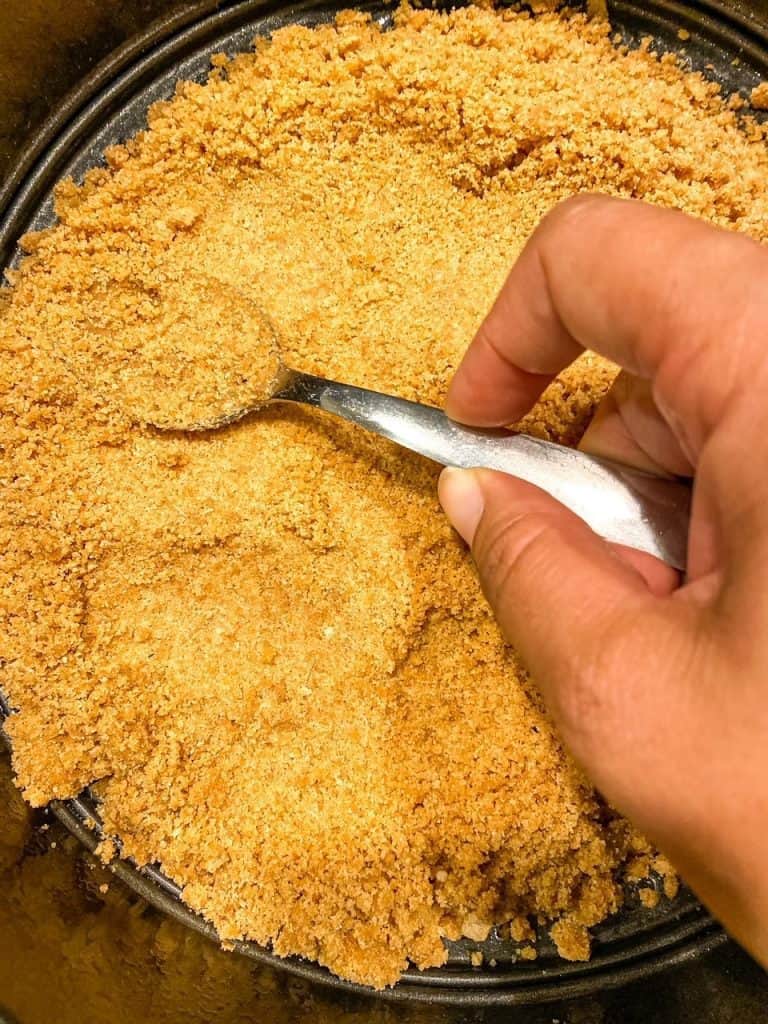 patting graham cracker crust down into pie dish