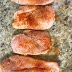chicken breast on cutting board with seasoning