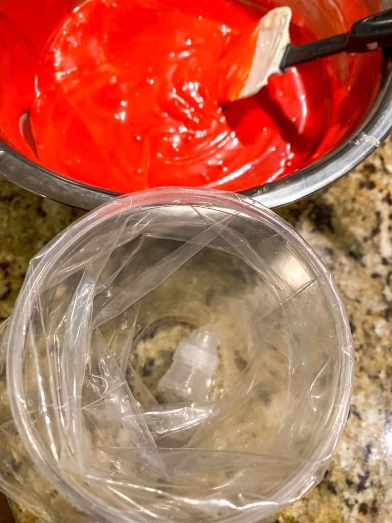 red velvet cheesecake mixture next to a piping bag to make swirl