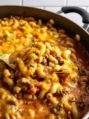 A big spoonful of Chili Mac and Cheese with a heaping pot of more behind it