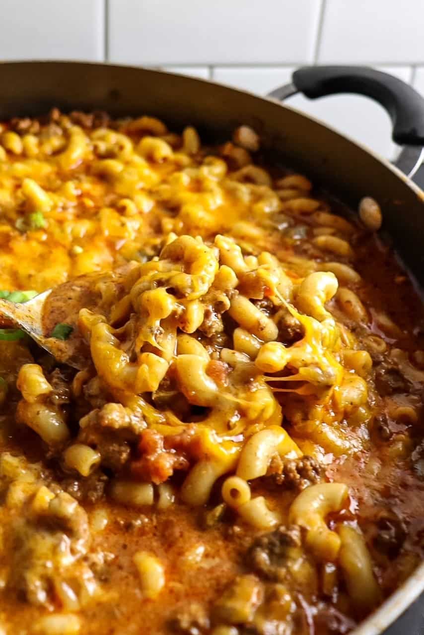 A big spoonful of Chili Mac and Cheese with a heaping pot of more behind it