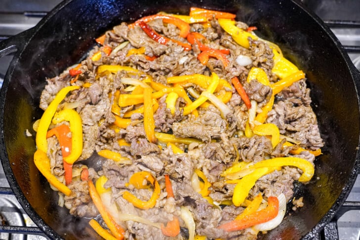 steak meat and peppers in a skillet for cheesesteak sandwich
