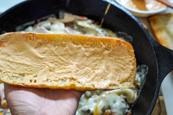 hoagie roll with sauce on it for a cheesesteak sandwich