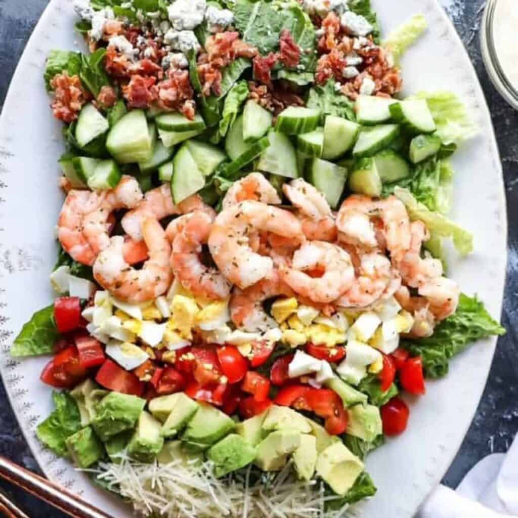 a platter of cobb salad with shrimp