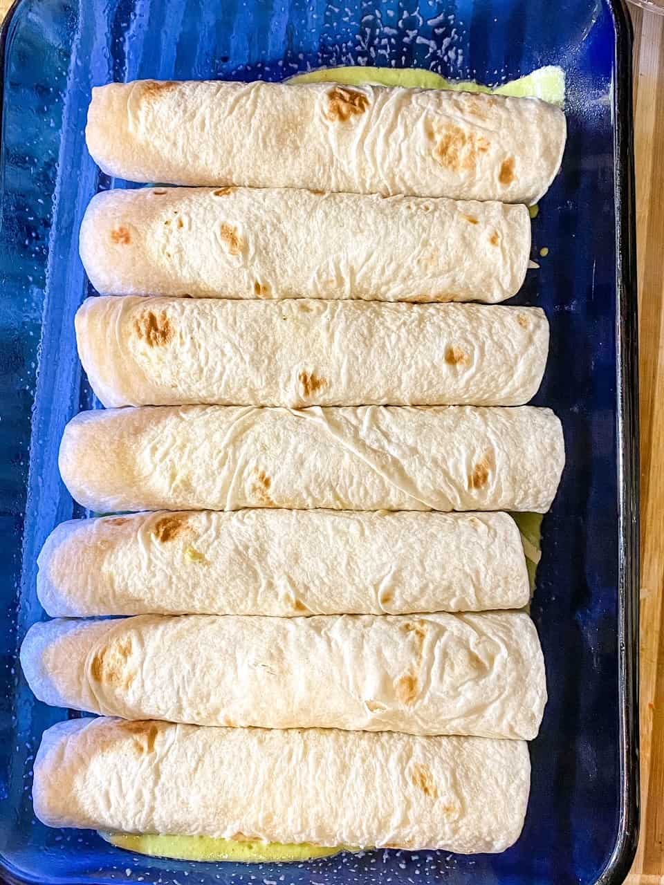 shrimp enchiladas rolled in tortillas placed in a baking dish