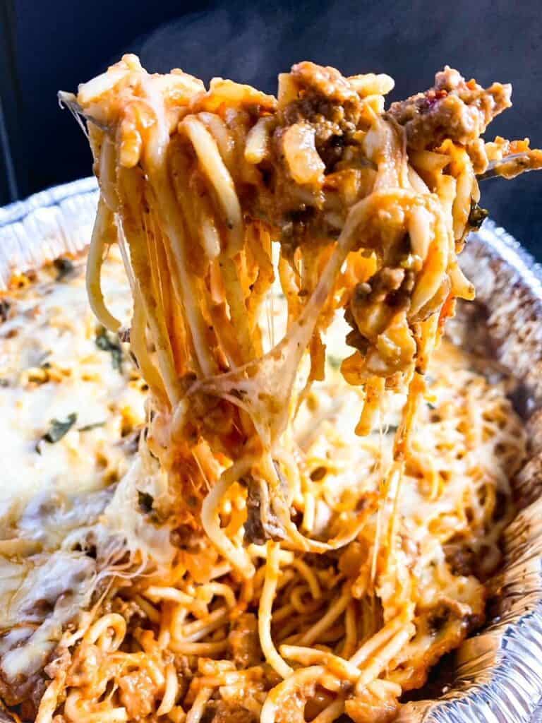 fork full of baked spaghetti with cheese pull