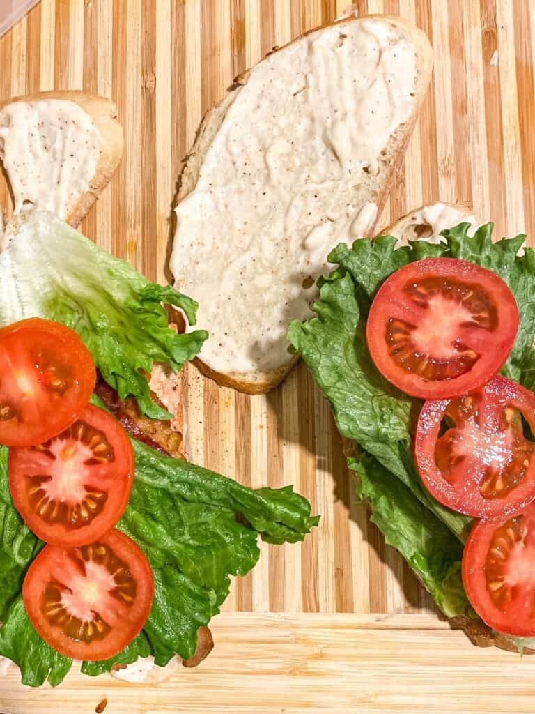 piece of bread with salmon, bacon, lettuce, and tomato on it to make a salmon BLT