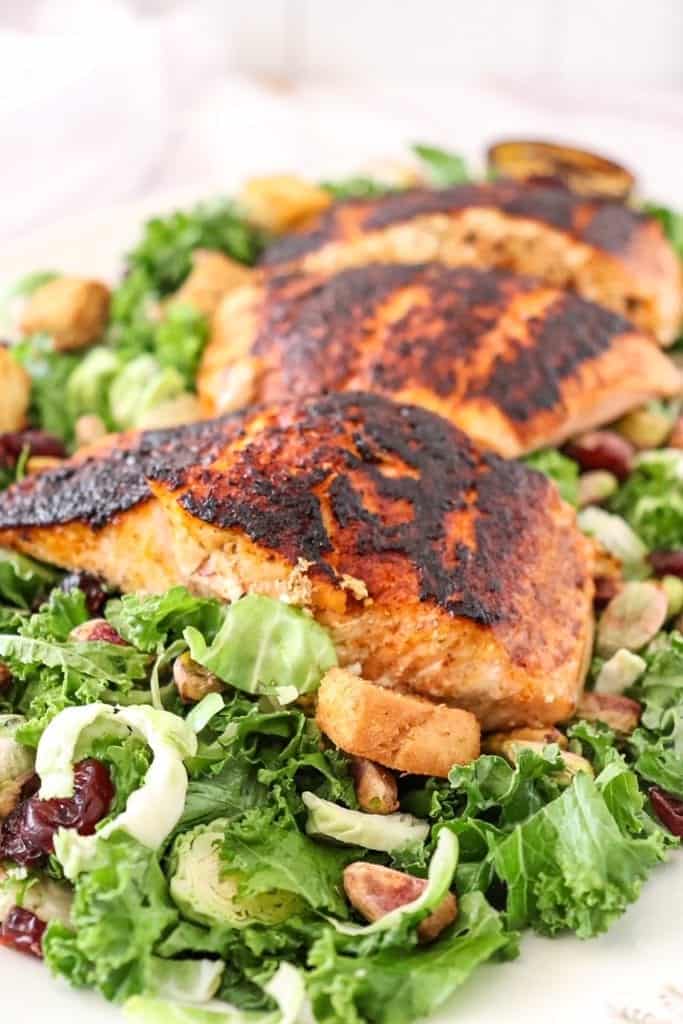 photo of kale salad on a platter with blackened salmon