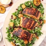photo of kale salad on a platter with blackened salmon