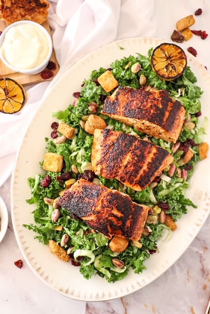 photo of kale salad on a platter with blackened salmon