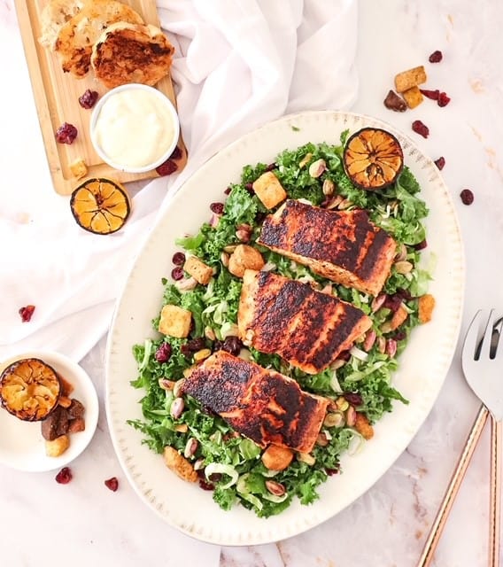 photo of kale salad on a platter with blackened salmon