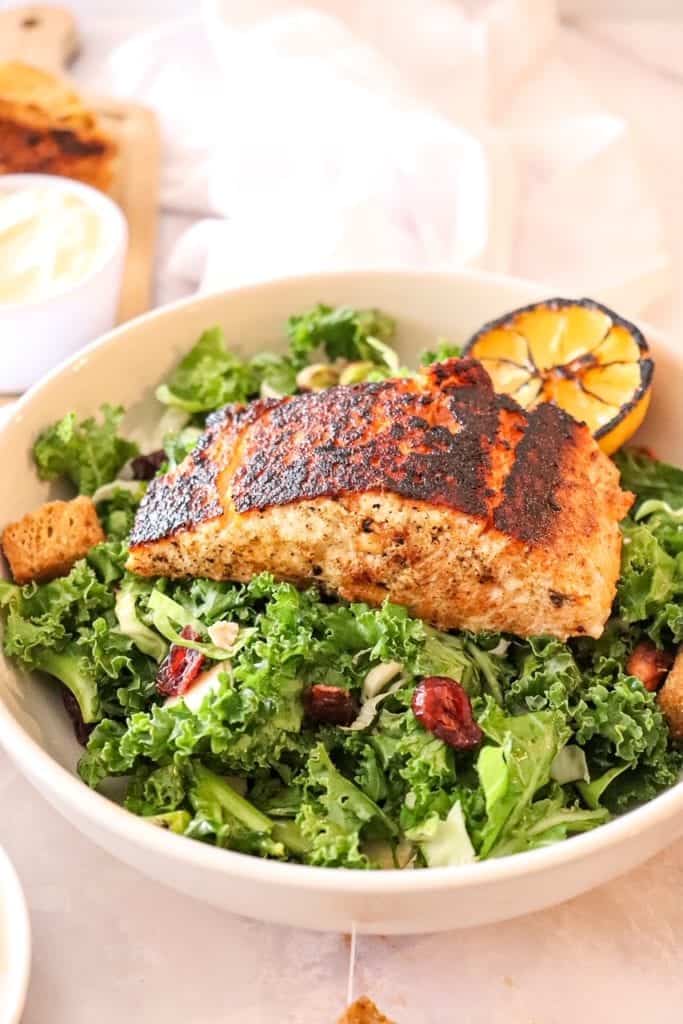 photo of kale salad in a bowl with blackened salmon