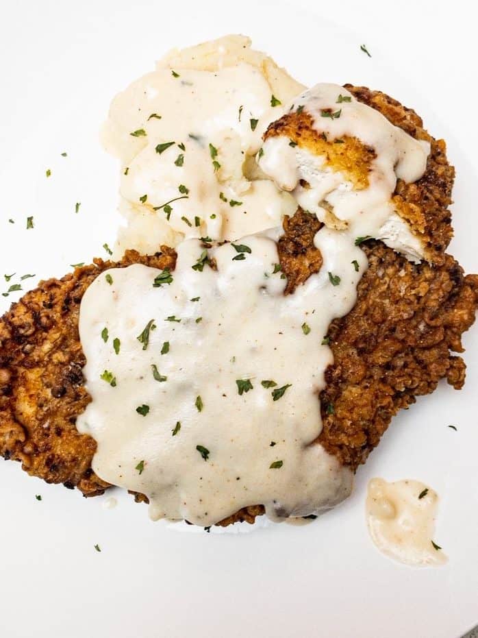 Buttermilk Brined Chicken Fried Chicken with country gravy over it