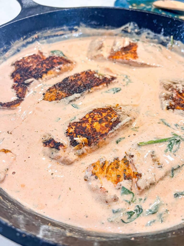 salmon in a cream sauce in a cast iron skillet