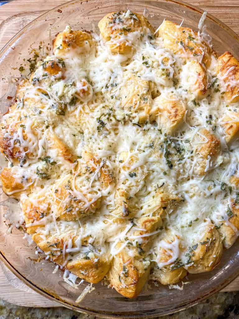 Overhead view of pull apart garlic cheese bread in a pan.