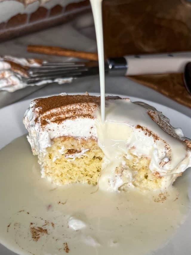 eggnog tres leches with eggnog pouring on a piece of cake
