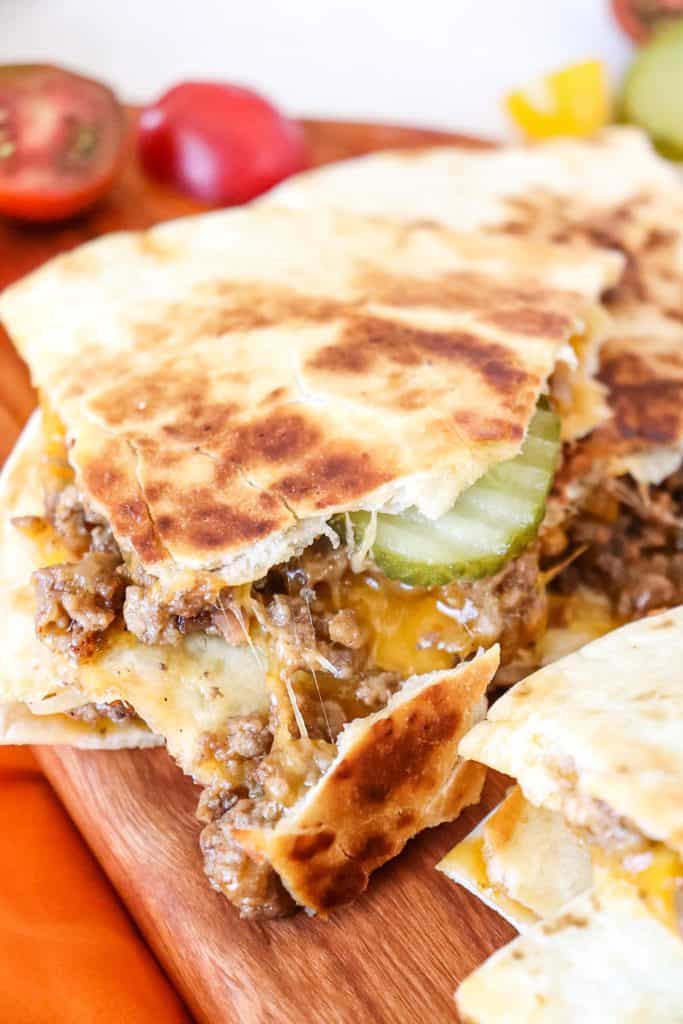 bacon cheeseburger quesadillas cut open sitting on a cutting board