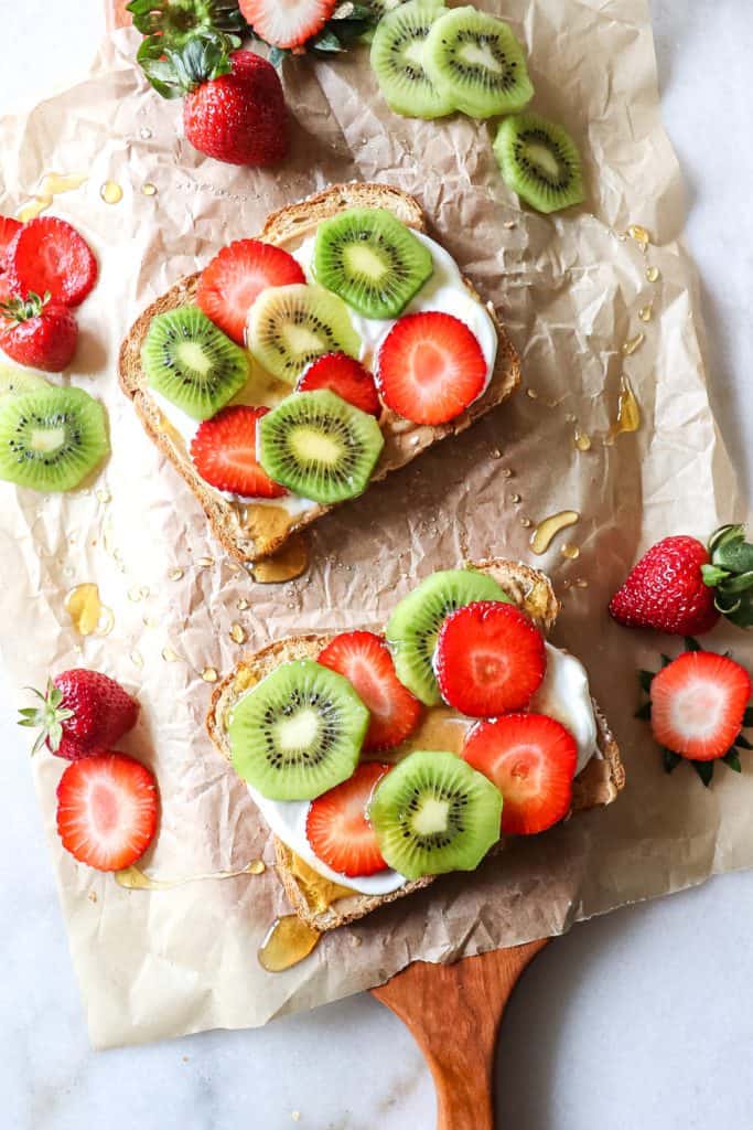peanut butter fruit toast on parchment paper on a cutting board