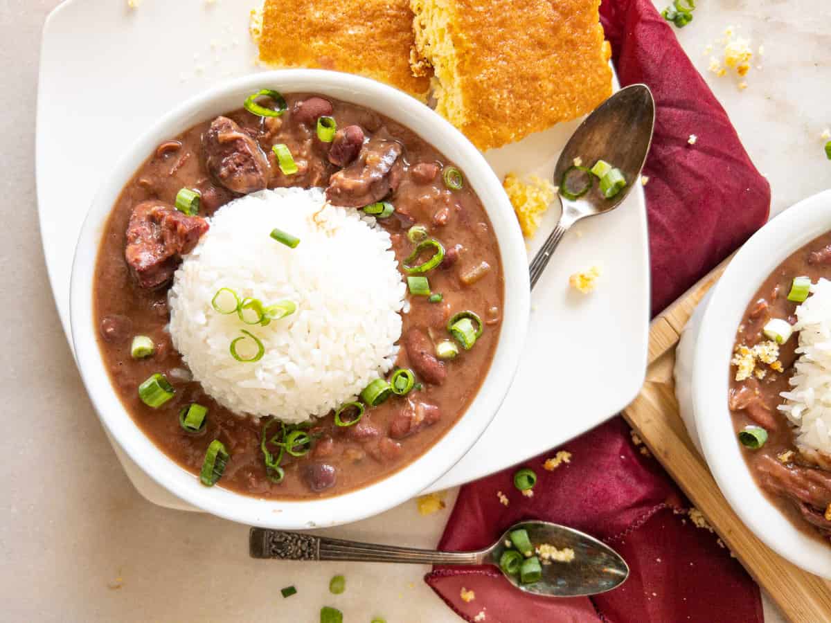a bowl of red beans and rice with a side of cornbread