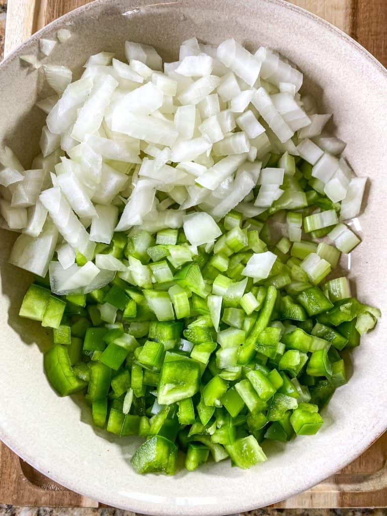 onion celery and bell pepper diced up in a bowl for red beans and rice recipe