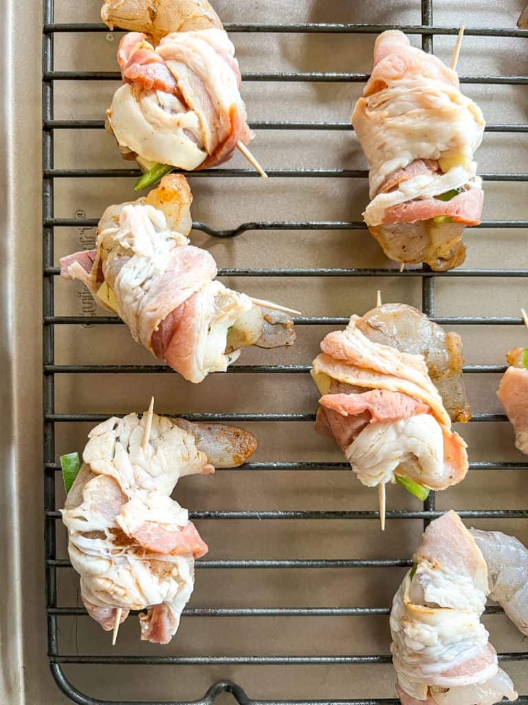 shrimp brochette wrapped in bacon on a baking tray