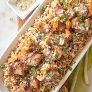 rice and shrimp brochette on a platter with garlic butter on top