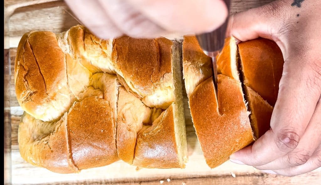 cutting small holes in the top of brioche bread slices to get ready to stuff for Peach cobbler stuffed French toast