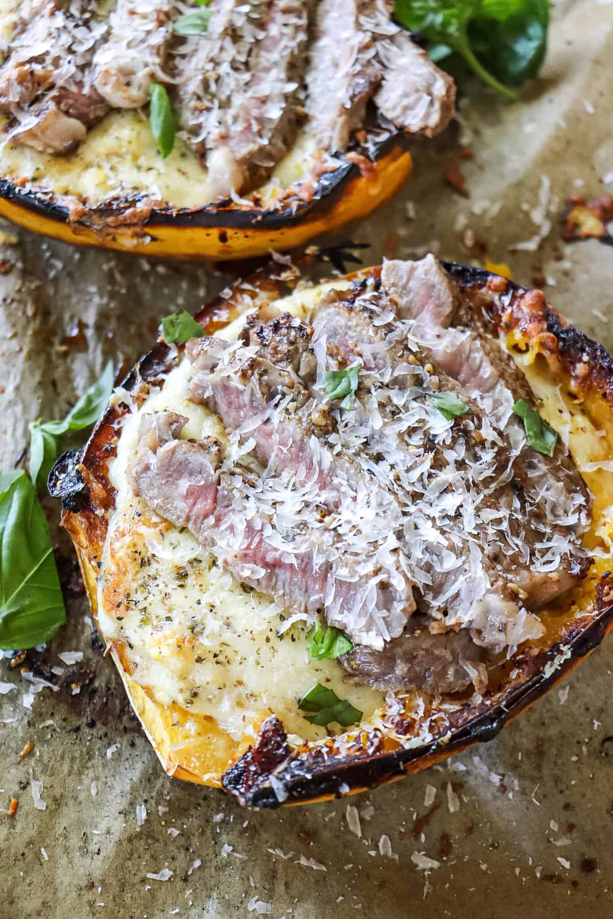 overhead view of sliced ribeye over a cheesy alfredo stuffed spaghetti squash