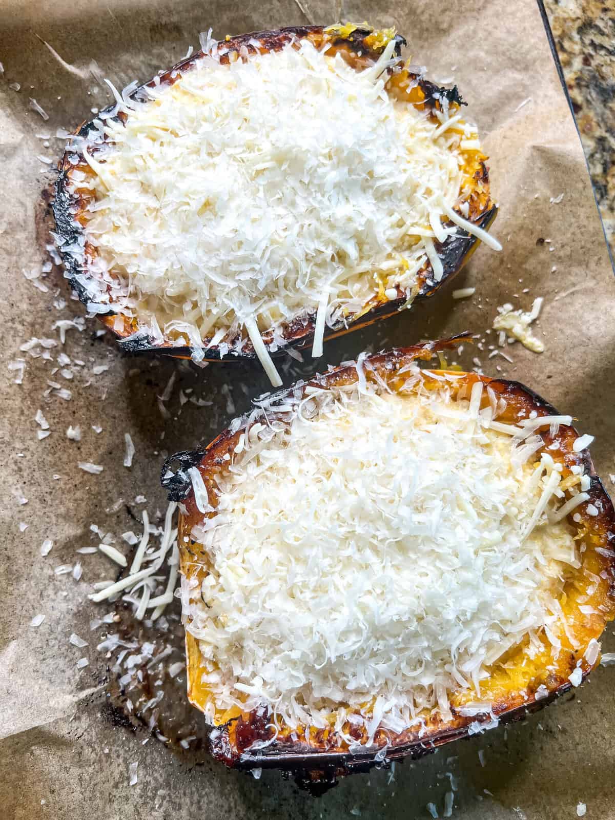 Shredded mozzarella cheese over two sliced of baked spaghetti squash 