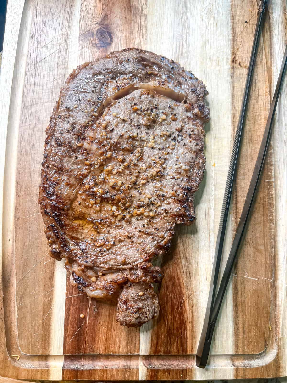 Cooked ribeye steak on a cutting board