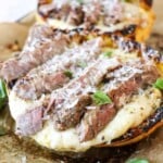 Close up view of sliced steak over spaghetti squash alfredo