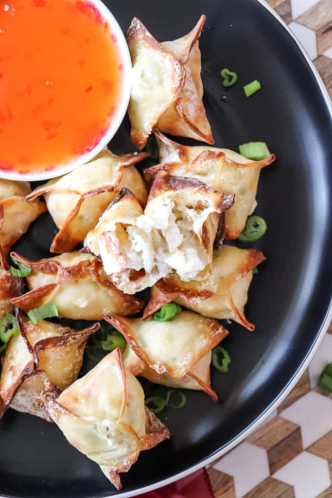 air fryer crab rangoon on a plate with a bowl of sweet chili sauce