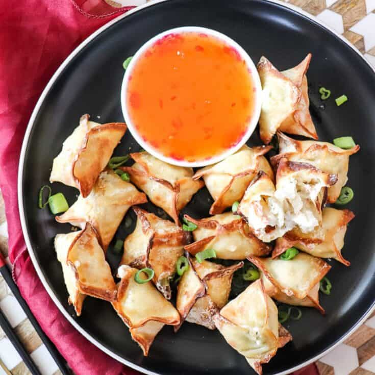 air fryer crab rangoon on a plate with a bowl of sweet chili sauce