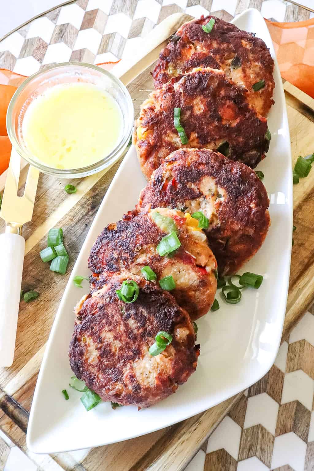 salmon croquettes on a platter with chopped green onions