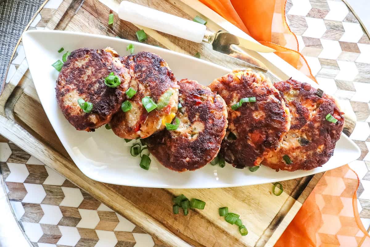 salmon croquettes on a platter with chopped green onions