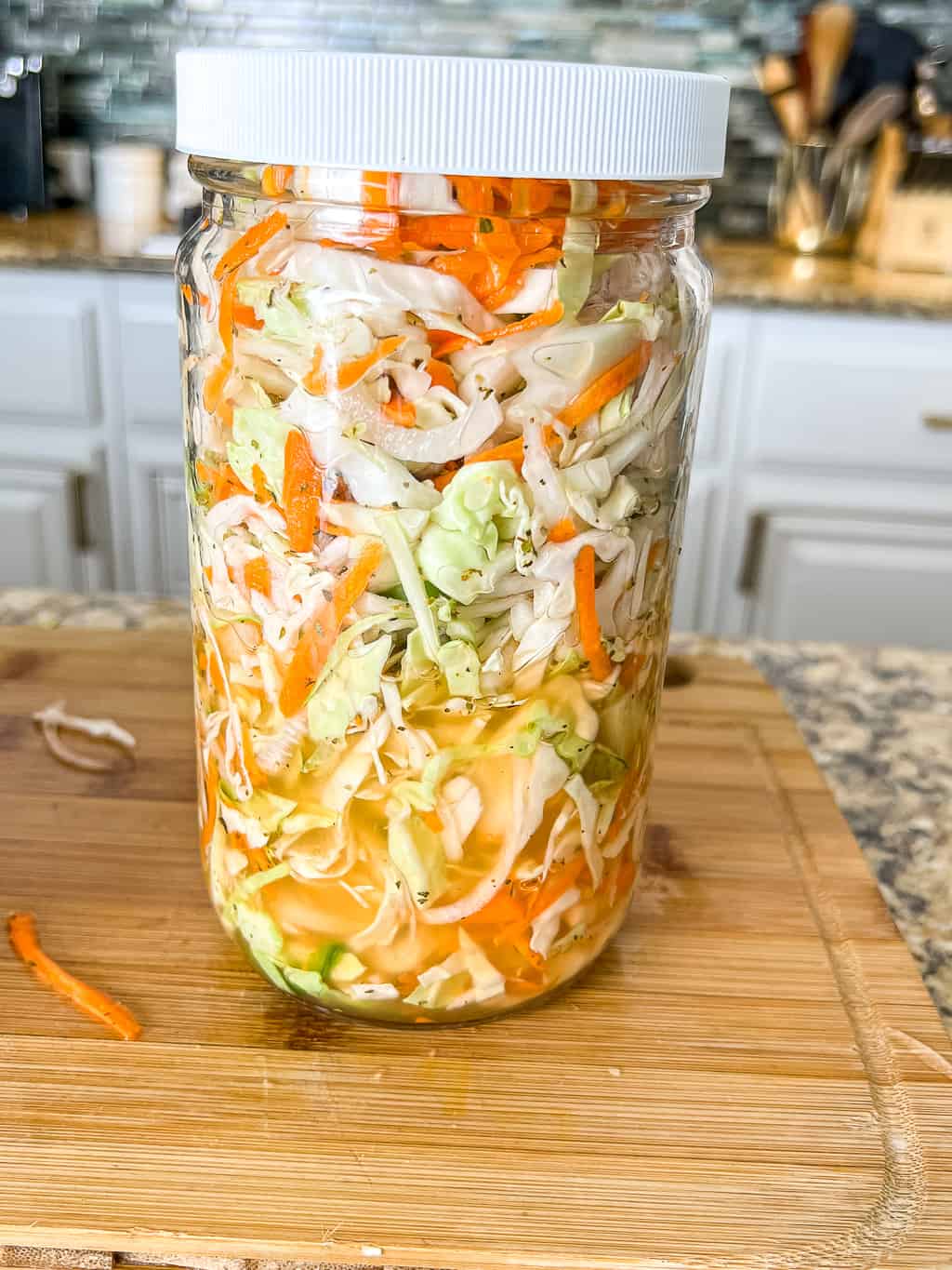curtido slaw in a large jar sitting on the counter