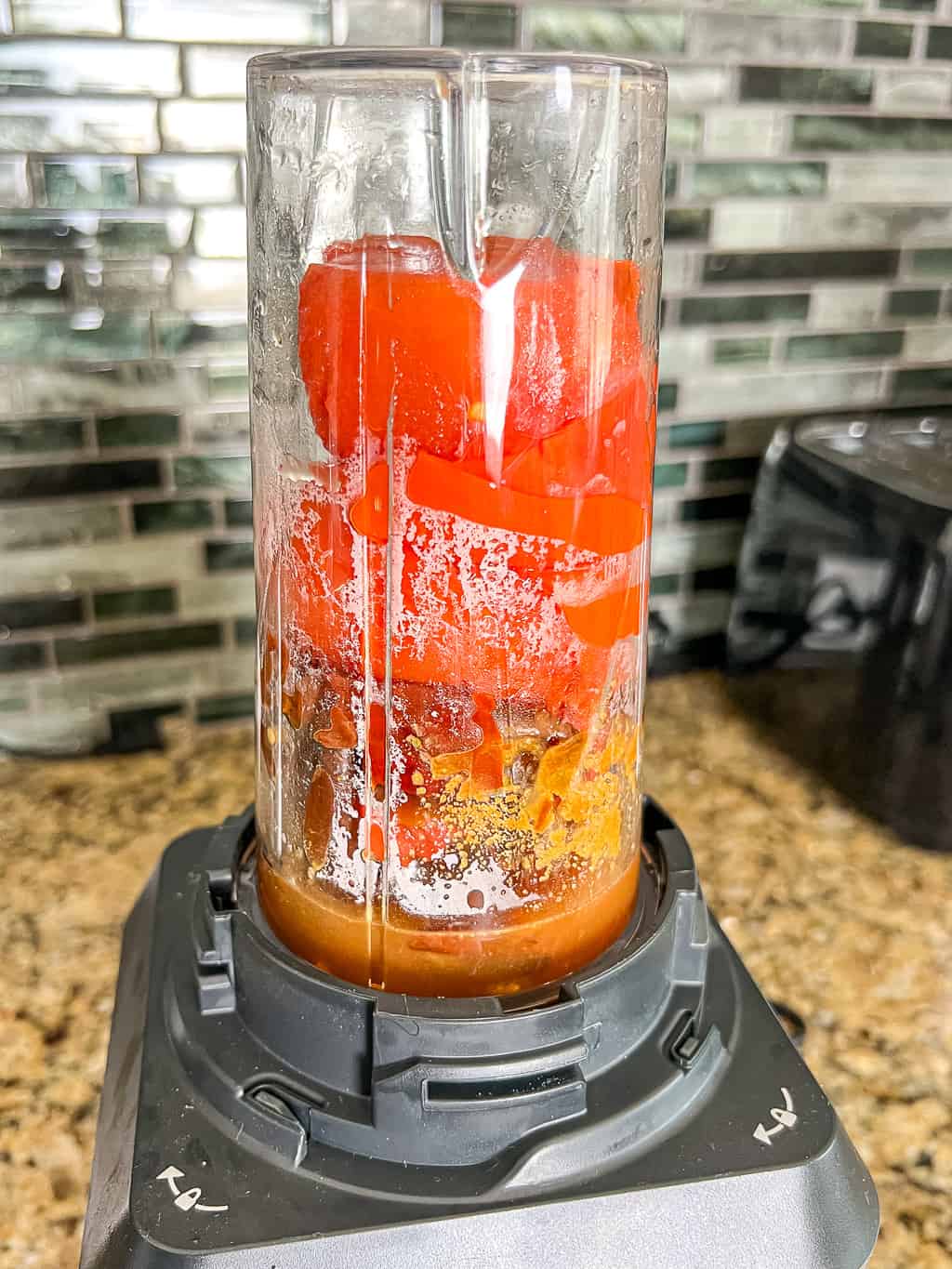 tomatoes and garlic in a blender to make salsa roja